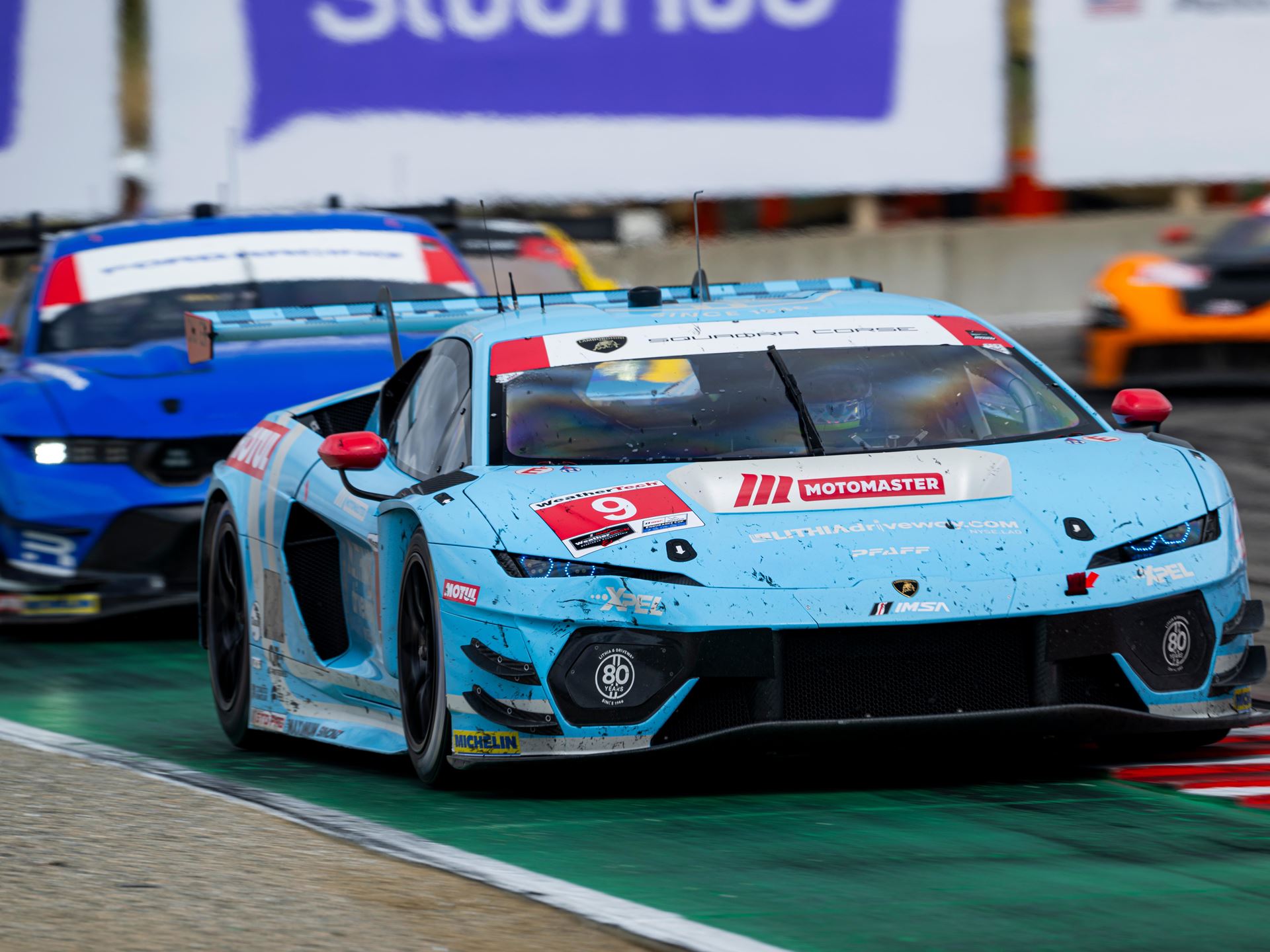 Huracán Gt3 Evo2 Wins At Laguna Seca While The Temerario Gt3 Posts Its Best Imsa Finish Yet 3 The #9 pfaff motorsports lamborghini temerario gt3 in light blue livery navigating a turn at laguna seca with aggressive front splitter and canards visible