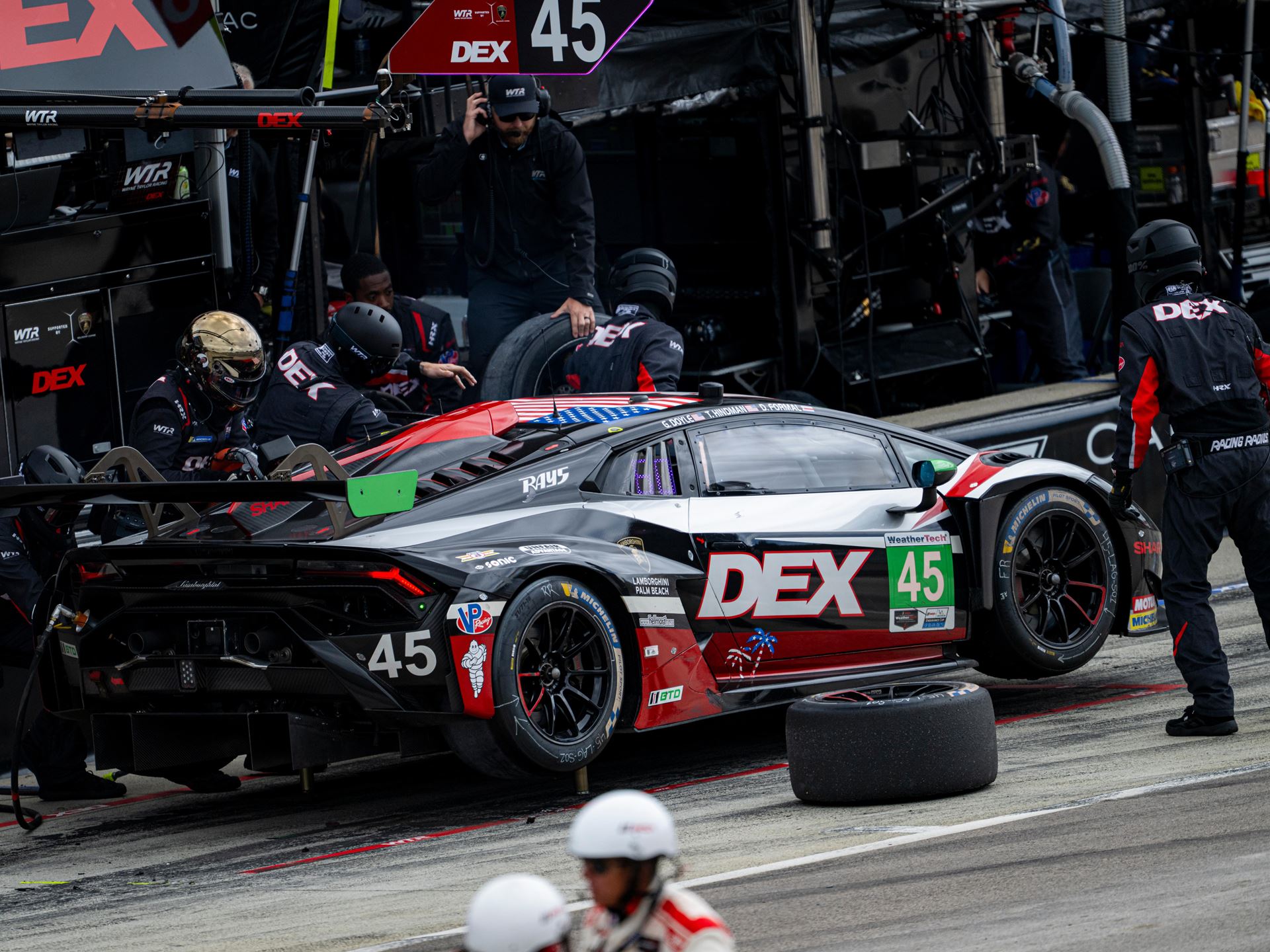 Huracán Gt3 Evo2 Wins At Laguna Seca While The Temerario Gt3 Posts Its Best Imsa Finish Yet 9 The #45 lamborghini huracán gt3 evo2 during a pit stop at laguna seca with crew members changing tires and a loose tire visible in the foreground